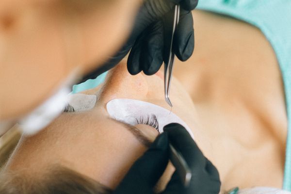 Beautician applying eyelash extensions in the salon