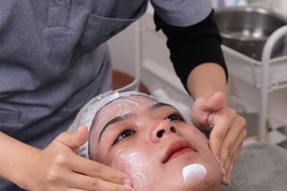 A skincare professional performing a facial treatment