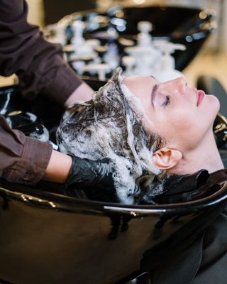 Client's hair being washed at the basin