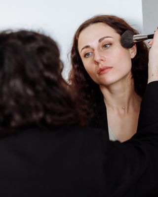 A makeup artist applying makeup to a client