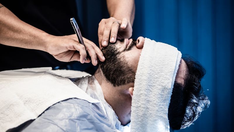 A reclined chair set for a hot-towel shave, towels warming beside it