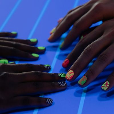 A client's hands with freshly painted nails after a manicure.