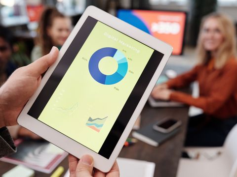 A hand holding a tablet